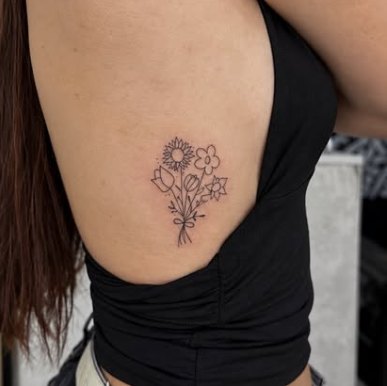 Ramo de flores em fine line nas costelas